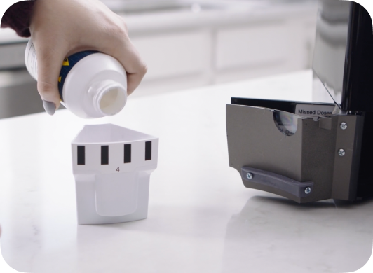 Pills being poured directly from a pill bottle into a MedaCube Bin.